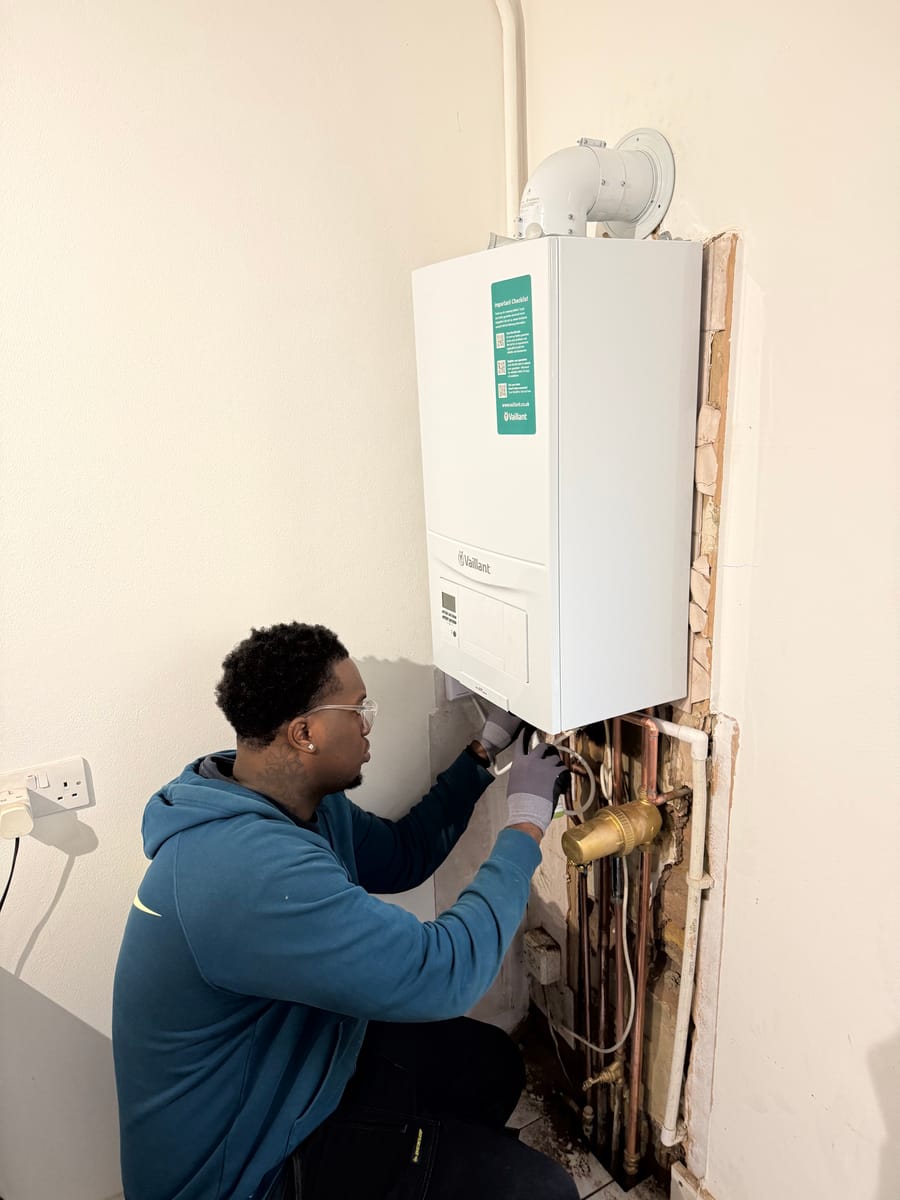 Gas Safe engineer connecting pipework to a new Vaillant combi boiler