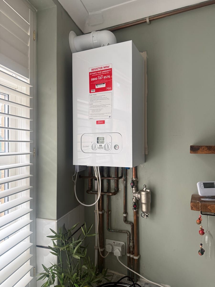 Completed Main Eco Compact combi boiler with copper pipework and a magnetic filter in a finished kitchen